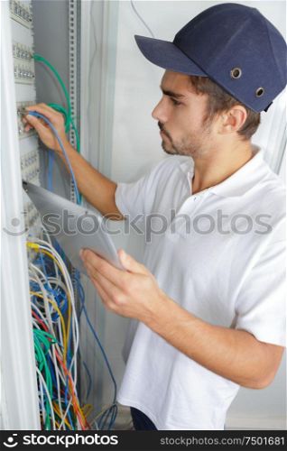 focused electrician applying safety procedure while working on electrical panel