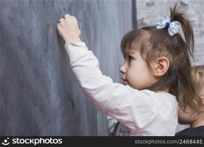 focused little girl writing blackboard