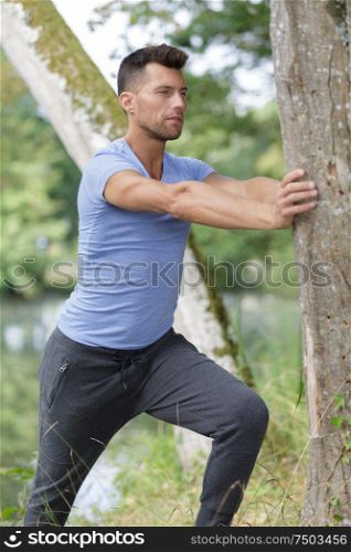 focused man stretching arm at outside the gym
