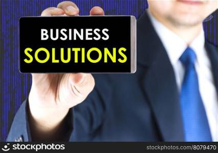 Focused of business solutions word on mobile phone screen in blurred young businessman hand and digital technology background