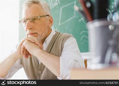 focused old professor looking away classroom