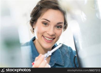 focused picture of woman holding screwdriver