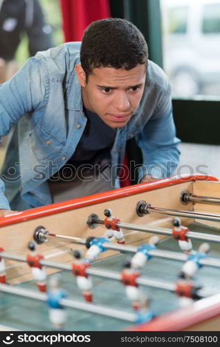 focused picture of young man playing babyfoot