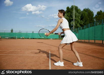 Focused pretty female tennis player preparing to hot ball. Outdoor training or competition match. Focused pretty female tennis player preparing to hot ball