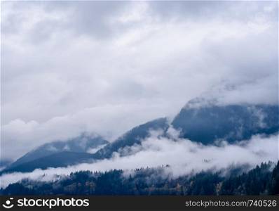 Fog and clouds covering forested mountains in British Columbia, Canada.
