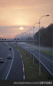 fog and rising sun in the morning on highway A28 near Utrecht De Uithof