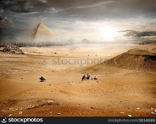 Fog and storm clouds over pyramid in desert