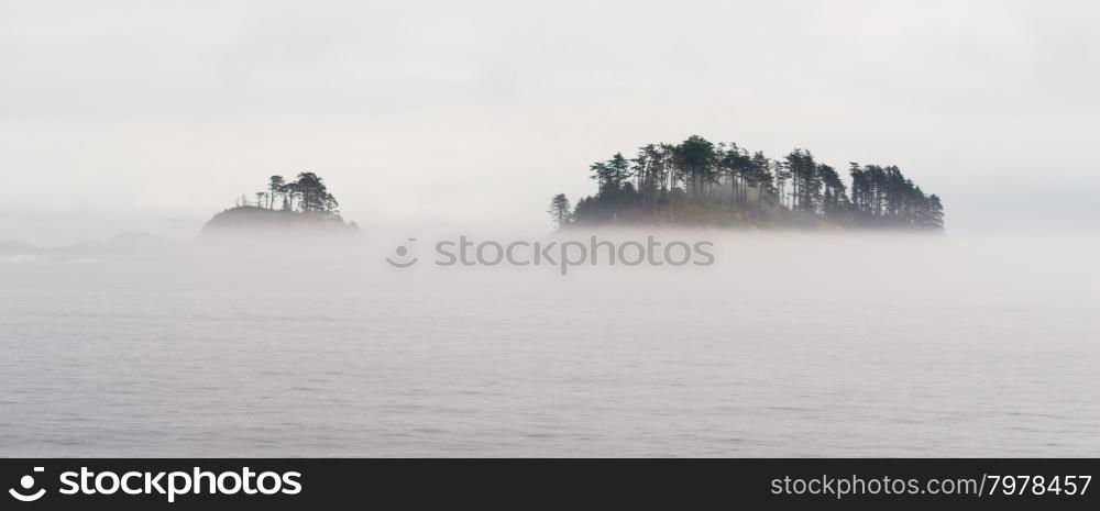 Fog surrounds a small island in the inside passage