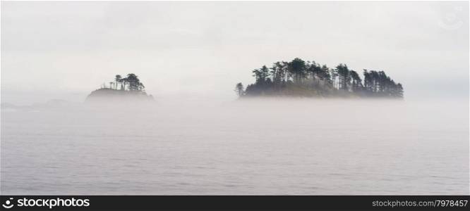 Fog surrounds a small island in the inside passage