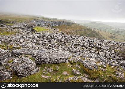 Fog sweeps over limestone pavement at Malham Cove in Yorkshire Dales National Park