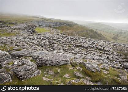 Fog sweeps over limestone pavement at Malham Cove in Yorkshire Dales National Park