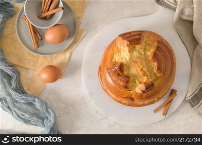 Fogaca on kitchen countertop with eggs and cinammon sticks. Traditional cake from Santa Maria da Feira, Portugal.