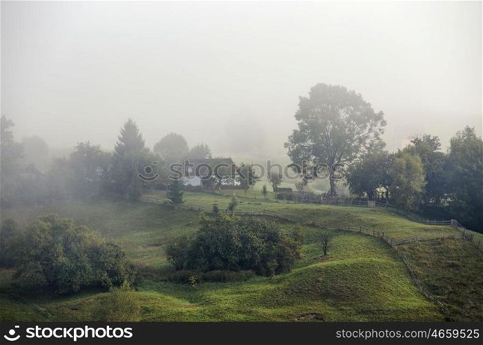 Foggy morning in a village on the hills of Carpathians