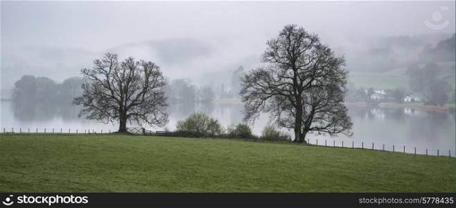 Foggy morning landscape over Lake Windermere in Lake District in England
