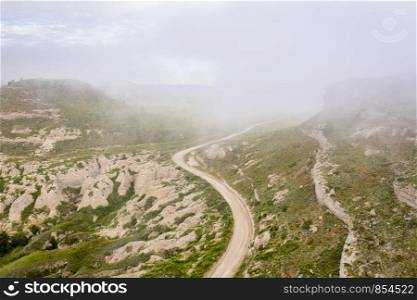 foggy morning over a windy road and rock outcropping in western Nebraska - aerial view