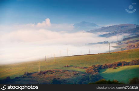 Foggy sunny morning in mountain village. Misty hills in Slovakia Tatras mountains. Town in valley.