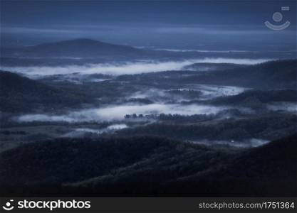 Foggy valleys during a blue overcast morning viewed from Skyline Drive in Shenandoah National Park.