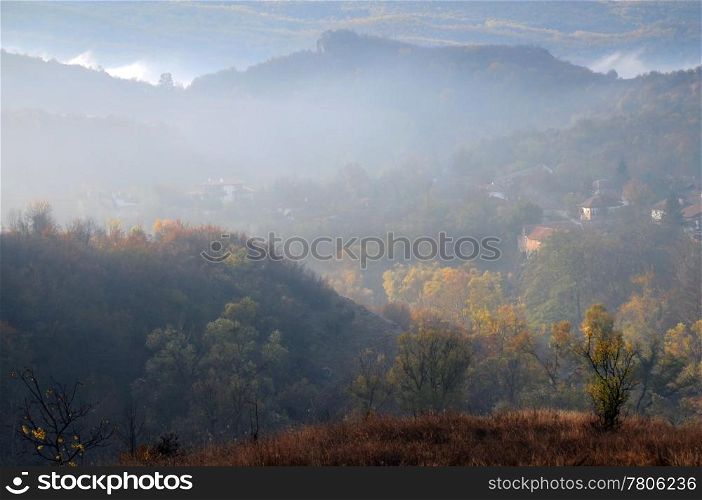 Foggy village in the mountains in the late fall