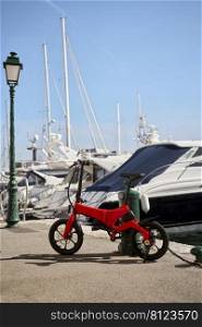 Foldable E-bike against a pole in the harbor        