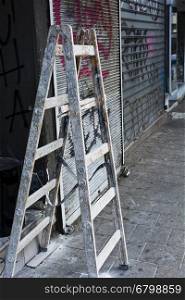 Foldable Wooden Ladder for Repairs of Shop in Tel Aviv. Splattered Ladder in the Street.
