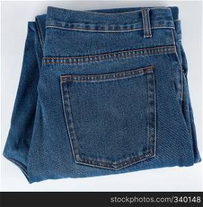 folded blue men's jeans on a white background, top view