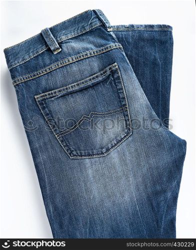folded blue men's jeans on a white background, top view