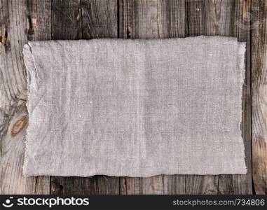 folded gray linen towel on wooden background, top view