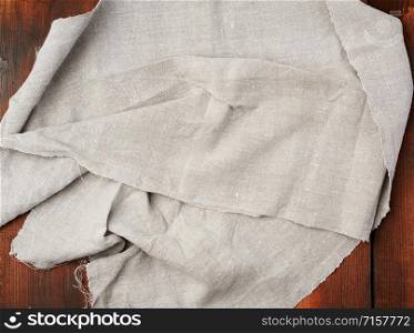 folded gray linen towel on wooden background, top view, copy space