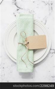 folded napkin tied with blank tag empty flat round plate