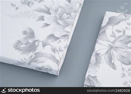 folded new bed linen with patterns on grey background, top view. bed linen on grey background