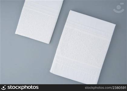 folded new tablecloth with embroidered patterns on a gray background, top view. tablecloth on a gray background