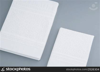 folded new tablecloth with embroidered patterns on a gray background, top view. tablecloth on a gray background