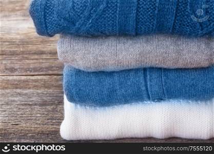 folded woolen clothes close up on wooden background. woolen clothes