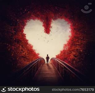 Follow your heart concept. A lone person lost in the autumn forest, found the way out of the woods, as walks a path through the heart shaped trees. Surreal and magic scene, red fall colors.