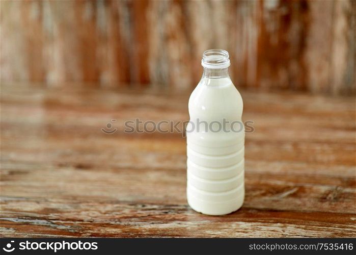 food and dairy products concept - bottle of milk on wooden table. bottle of milk on wooden table