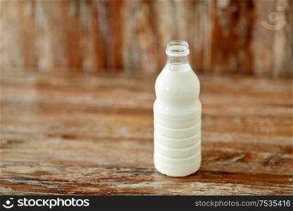 food and dairy products concept - bottle of milk on wooden table. bottle of milk on wooden table