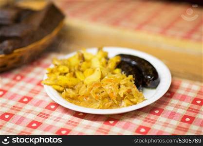 food and eating concept - braised cabbage, potato and sausages on plate. braised cabbage and sausages with sauce on plate
