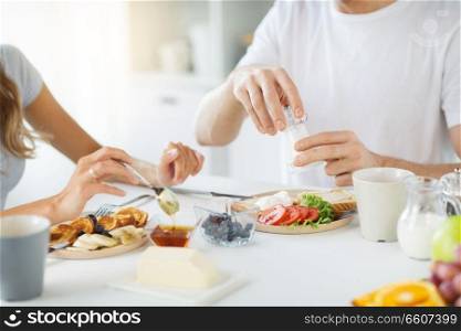 food and eating concept - close up of couple having breakfast at home. close up of couple having breakfast at home