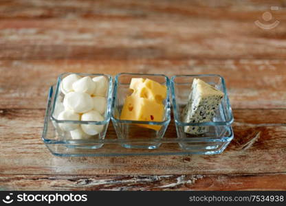 food and eating concept - different kinds of cheese in glass cups. different kinds of cheese in glass cups