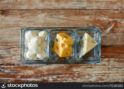 food and eating concept - different kinds of cheese in glass cups. different kinds of cheese in glass cups
