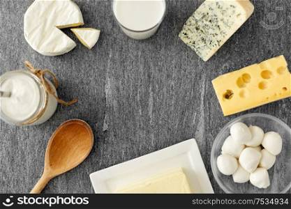 food and eating concept - different kinds of cheese, milk, yogurt and butter on stone table. different kinds of cheese, milk, yogurt and butter