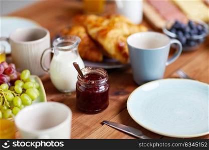food and eating concept - jar with jam on wooden table at breakfast. jar with jam on wooden table at breakfast