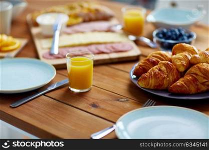 food and eating concept - plate of croissants on wooden table at breakfast. plate of croissants on wooden table at breakfast