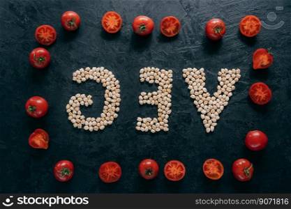Food and nutrition concept. Horizontal shot of dry garbanzo in form of letter VEG, denoting products for vegans. Tomato frame around