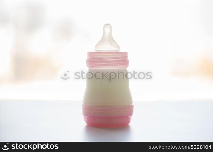 food and nutrition concept - infant milk formula in baby bottle on table. infant milk formula in baby bottle on table