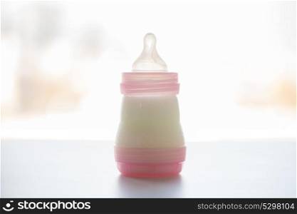 food and nutrition concept - infant milk formula in baby bottle on table. infant milk formula in baby bottle on table