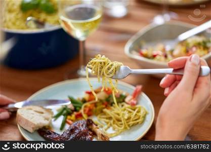 food and people concept - hands of woman with fork and knife eating pasta. hands of woman eating pasta
