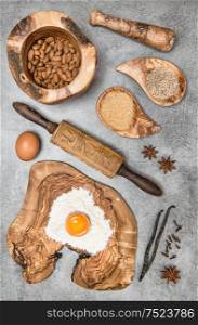 Food background. Baking utensils and ingredients on kitchen table. Eggs, flour, sugar, almond, vanilla