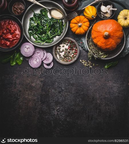 Food background for healthy vegetarian cooking ingredients for tasty pumpkin dishes recipes in bowls : tomato sauces, spinach, sliced onion, pumpkin seeds, top view, banner. Clean seasonal eating