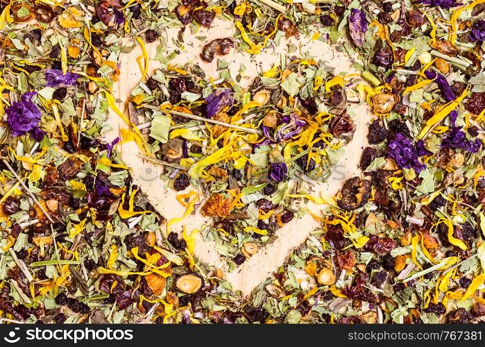 Food background of assorted natural medical dried herb leaves and flower petals with shape of heart. Assorted natural medical herbs with shape of heart